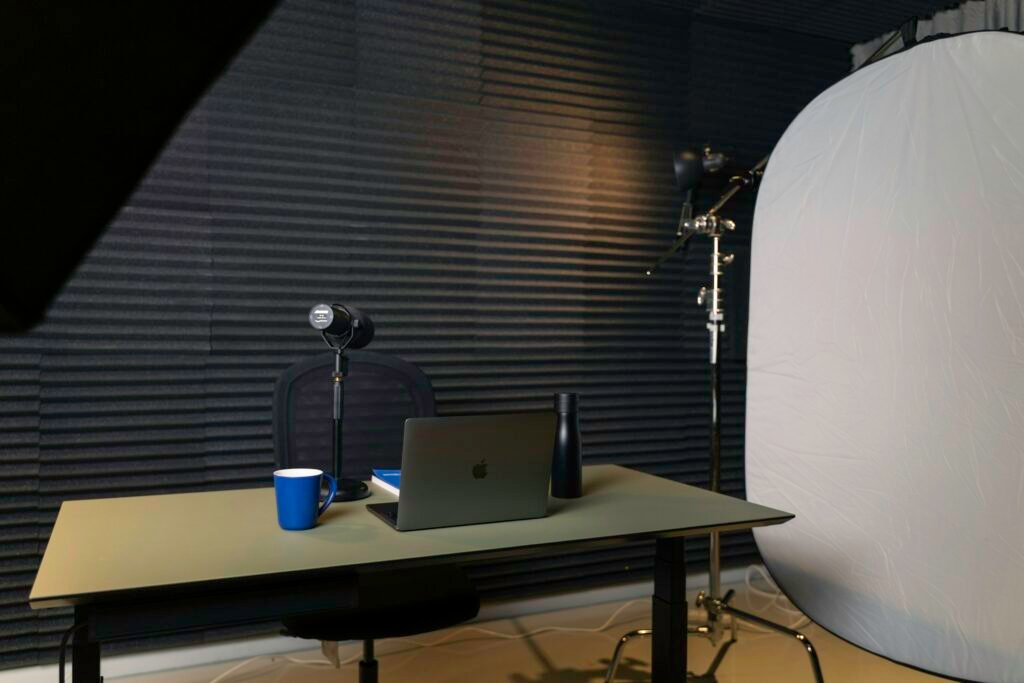 Podcast studio desk with microphone, laptop and recording equipment